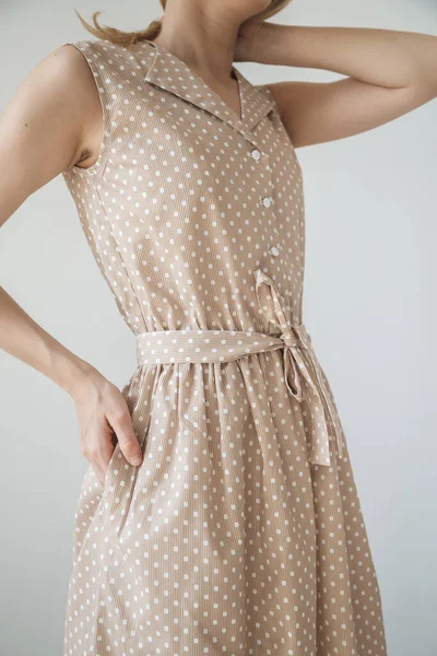 Güzel, açık kahverengi bir elbise ve bir kızın üzerinde benekler var. Elini cebime koy. 