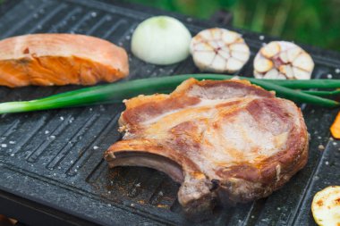 Izgarada çiğ et ve balık bifteği