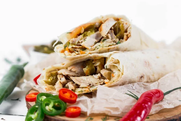 Shawarma con pollo, con salsa, cebollas, encurtidos, hierbas y pimiento rojo picante sobre un fondo claro — Foto de Stock