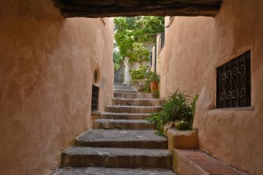 İtalya 'nın Calabria bölgesindeki bir ortaçağ köyü olan Scalea' nın eski evleri arasında dar bir sokak..