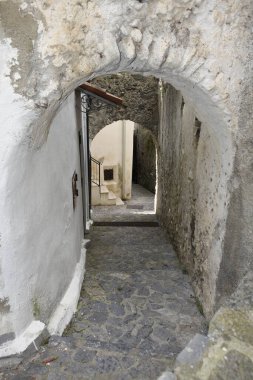 İtalya 'nın Calabria bölgesindeki bir ortaçağ köyü olan Scalea' nın eski evleri arasında dar bir sokak..