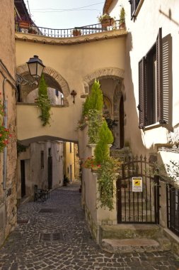 İtalya 'nın Lazio bölgesindeki bir ortaçağ köyü olan Giuliano di Roma' nın eski evleri arasında dar bir sokak.