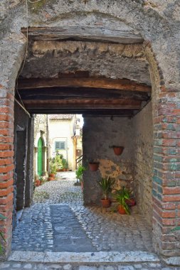 Lazio bölgesindeki ortaçağ köyü Prossedi 'nin eski evleri arasında dar bir sokak..
