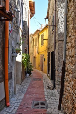 Lazio bölgesindeki ortaçağ köyü Prossedi 'nin eski evleri arasında dar bir sokak..