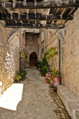 İtalya 'nın Lazio bölgesindeki bir ortaçağ köyü olan Vallecorsa' nın eski evleri arasında dar bir sokak.