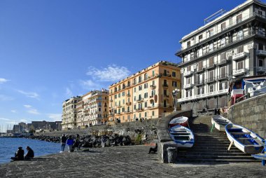 Naples, Italy, December 2020. People walking along the city's waterfront on a sunny winter day.