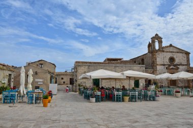 Marzameni, İtalya, Haziran 2019. Sicilya kıyısındaki bir köyün meydanındaki bir restoranın masaları..