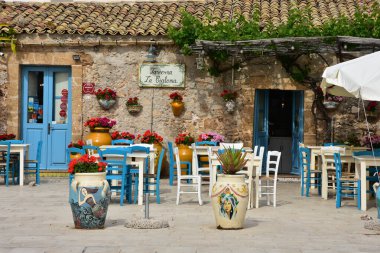Marzameni, İtalya, Haziran 2019. Sicilya kıyısındaki bir köyün meydanındaki bir restoranın masaları..