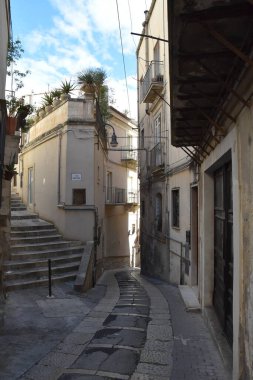 İtalya 'nın Sicilya bölgesindeki eski bir kasaba olan Modica evleri arasında dar bir sokak..
