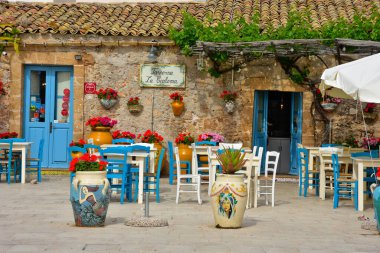 Marzameni, İtalya, Haziran 2019. Sicilya kıyısındaki bir köyün meydanındaki bir restoranın masaları..