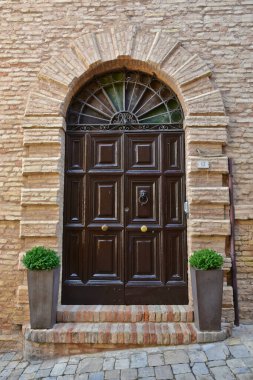 CivitanovaAlta, İtalya, 07 / 22 / 2018. Marche bölgesinde bir ortaçağ köyünde eski bir evin kapısı..