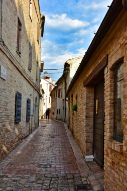 İtalya 'nın Marche bölgesinde bir ortaçağ kasabası olan Civitanova Alta' nın eski evleri arasında dar bir sokak..