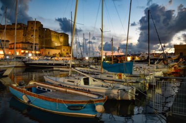 Naples, Italy, 10/10/2016. Fishing boats in the oldest part of the harbor, near a medieval castle.