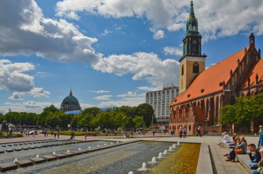 Berlin, Almanya, 26 Temmuz 2015. Şehir merkezinde çeşmeleri olan bir meydanda turistler.