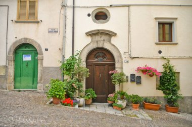 İtalya 'nın Molise bölgesindeki dağların ortaçağ köyü Agnone' nin eski evleri arasında küçük bir sokak..