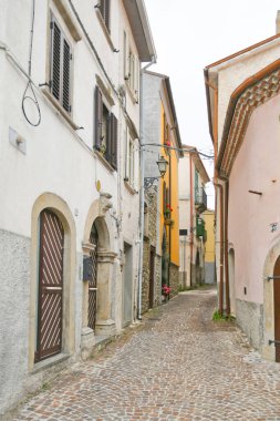 İtalya 'nın Molise bölgesindeki dağların ortaçağ köyü Agnone' nin eski evleri arasında küçük bir sokak..