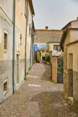 İtalya 'nın Molise bölgesindeki dağların ortaçağ köyü Agnone' nin eski evleri arasında küçük bir sokak..