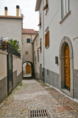 İtalya 'nın Molise bölgesindeki dağların ortaçağ köyü Agnone' nin eski evleri arasında küçük bir sokak..