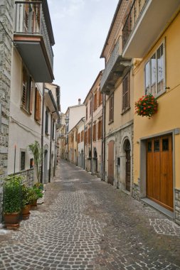 İtalya 'nın Molise bölgesindeki dağların ortaçağ köyü Agnone' nin eski evleri arasında küçük bir sokak..