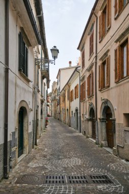 İtalya 'nın Molise bölgesindeki dağların ortaçağ köyü Agnone' nin eski evleri arasında küçük bir sokak..