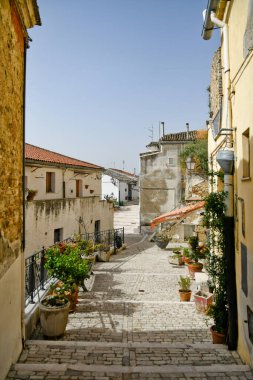 İtalya 'nın Puglia bölgesinde bir ortaçağ köyü olan Candela' daki eski evlerin arasında küçük bir sokak..