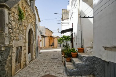 İtalya 'nın Puglia bölgesinde bir ortaçağ köyü olan Candela' daki eski evlerin arasında küçük bir sokak..