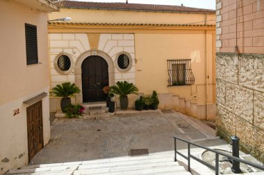 İtalya 'nın Puglia bölgesinde bir ortaçağ köyü olan Candela' daki eski evlerin arasında küçük bir sokak..