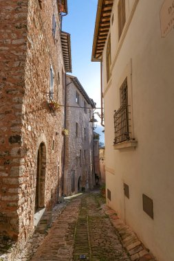 İtalya 'nın Umbria bölgesinde bir ortaçağ köyü olan Trevi' nin eski evleri arasında bir sokak..