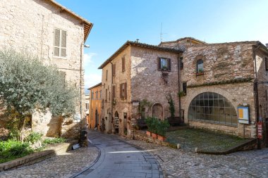 İtalya 'nın Umbria bölgesinde bir ortaçağ köyü olan Spello' nun eski taş evleri arasında bir sokak..
