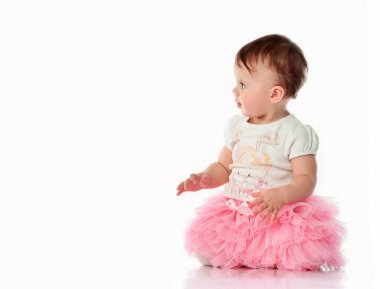 Beyaz arka planda pembe etekli altı aylık kız.