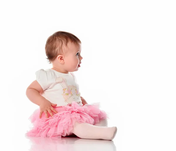 Förvånad småbarn flicka sitter på vitt golv — Stockfoto