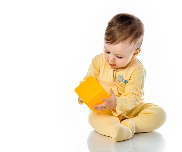 Bebê em camisa amarela brincando com blocos brilhantes olhando para cima em surpresa — Fotografia de Stock