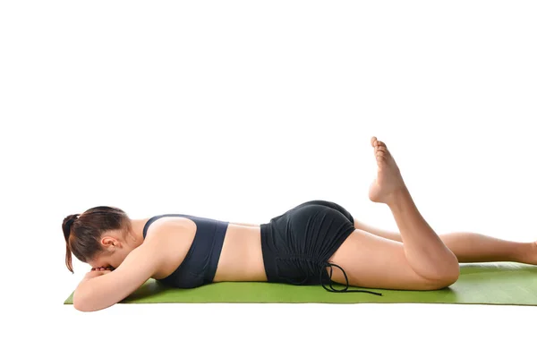 Sportovní dívka leží na sportovní podložce lícem dolů a medituje po cvičení jógy. — Stock fotografie