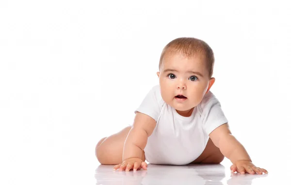 Surprised baby kid creeping on white studio floor — Stock Photo, Image