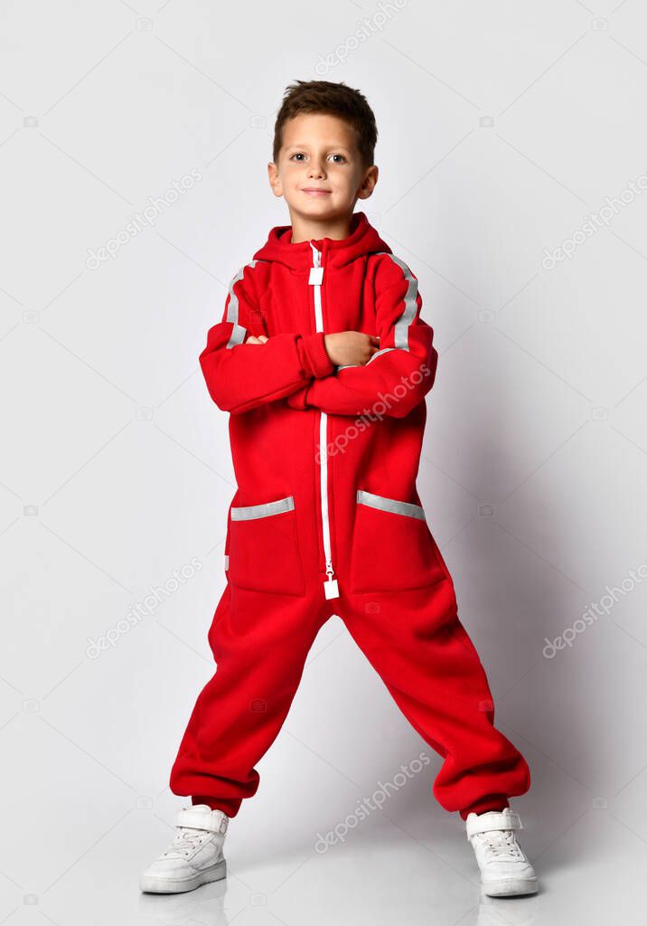 Boy in red warm jumpsuit showing victory gesture
