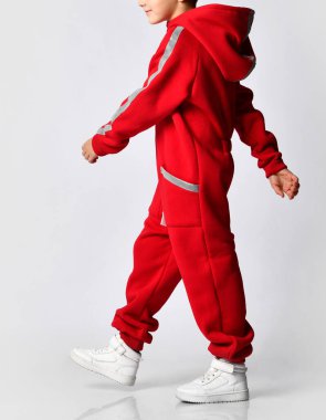 Kırmızı, sıcak, tulumlu stüdyo fotoğrafı çeken bir çocuk.