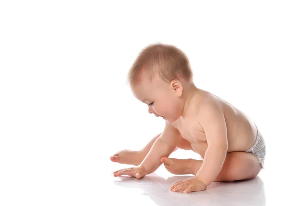 Adorabile bambino seduto e guardando da parte su sfondo bianco — Foto Stock