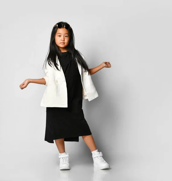 Little asian girl model posing in studio on a white background with outstretched hands. — ストック写真