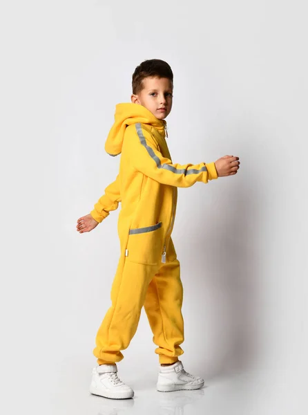 Stylish kid schoolboy in a warm autumn suit, yellow overalls with a zipper — Stock Photo, Image