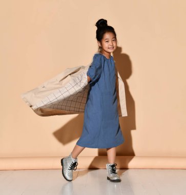 Kız giyinmiş, başparmağını kaldırıyor ve bu kıyafetin içinde neye benzediğini gösteriyor..