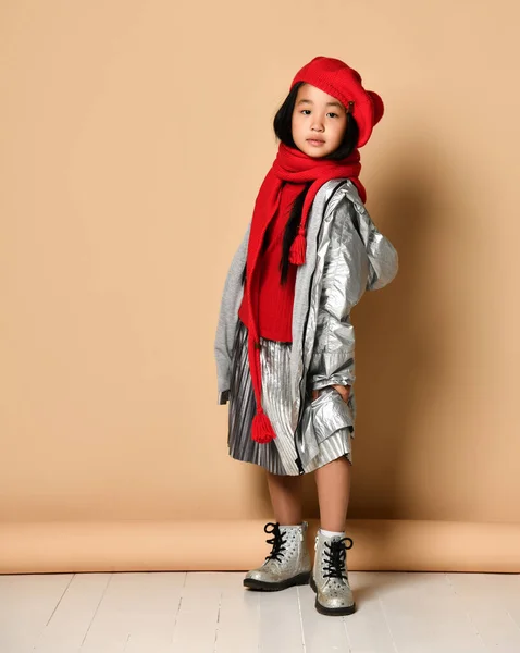 赤いベレー帽、スカーフ、セーター、銀のスカートとジャケットを身に着けているアジアの小さなモデルの女の子は楽しい. — ストック写真