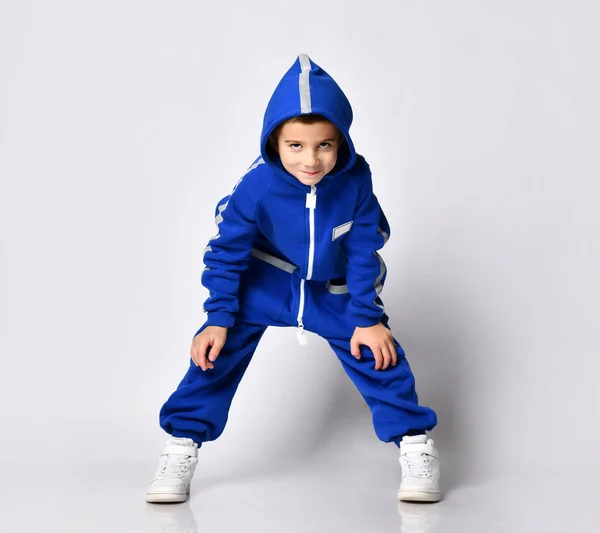 Beyaz bir arka planda mavi spor modasına uygun, neşeli ve neşeli bir çocuk.. — Stok fotoğraf