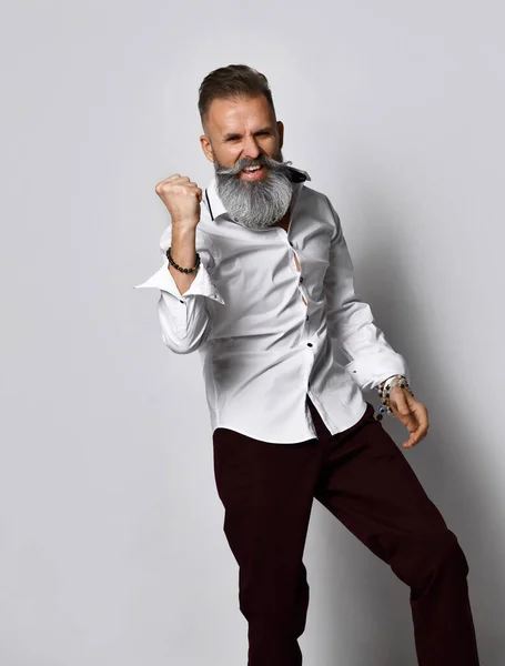 Homme élégant avec une barbe grise et la moustache se tient sur un fond gris et regarde la caméra. — Photo