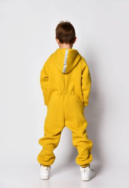 Sarı tulum giyen çocuk stüdyo görüntüsü.