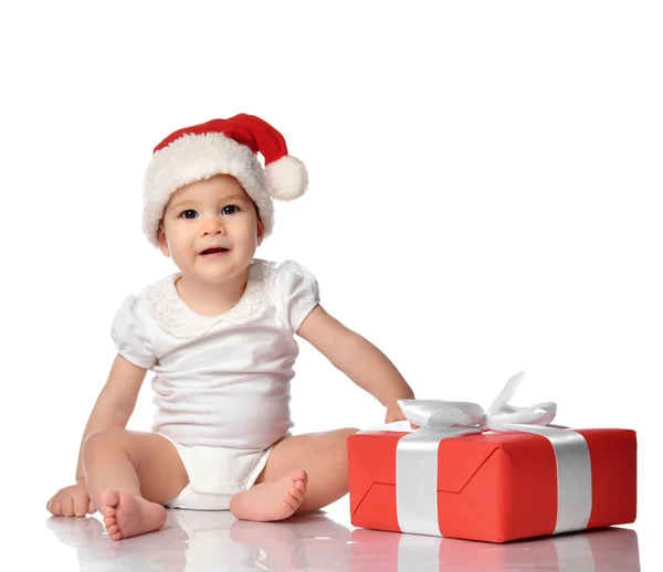 Infant baby girl child in red Santa hat with gift box — Stock Photo, Image
