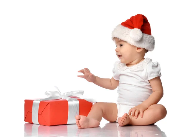 Немовля в червоній шапці Санта з видом збоку подарункової коробки — стокове фото