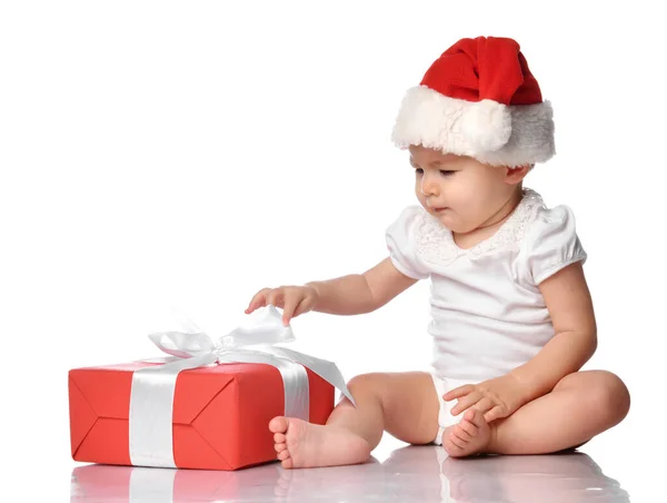 Bebé infantil en gorra Santa roja con vista lateral de caja de regalo Imagen De Stock