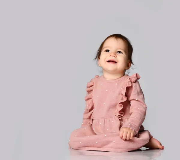 Menina adorável sentado em um lindo vestido rosa com uma saia — Fotografia de Stock