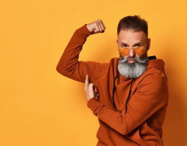 Güçlü sakallı adam güç ve kas gösteriyor.