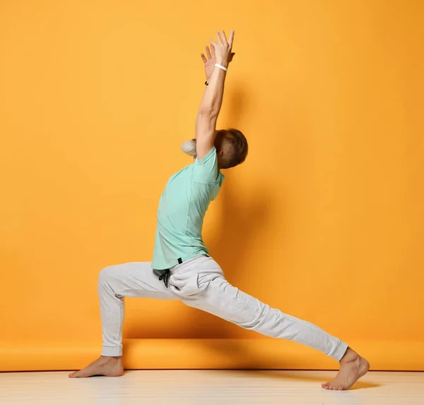 Un uomo. Uomo che fa yoga su uno sfondo giallo — Foto Stock